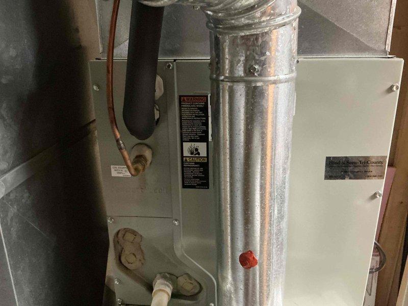Completed estimate for replacement of 21-year-old residential air conditioning system. Evaluated existing outdoor condensing unit showing signs of age and wear, positioned on cracked concrete pad adjacent to home exterior. Assessed indoor air handler/furnace unit located in basement utility area with connected ductwork and refrigerant lines. Documented current system configuration including copper refrigerant piping, PVC condensate drainage, and galvanized supply ductwork. Provided replacement recommendations and pricing options for new AC system installation.