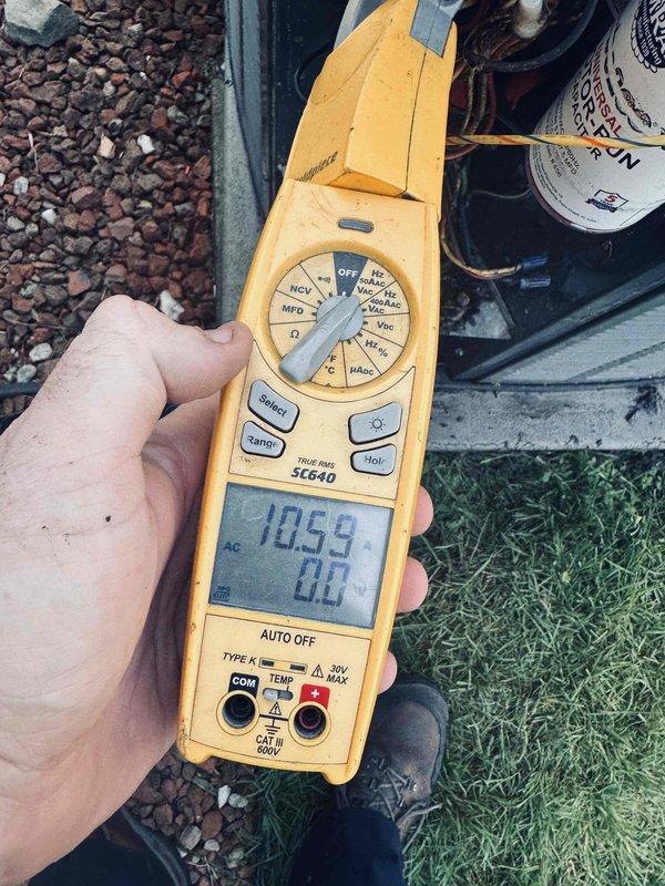 Responded to no cooling complaint on 16-year-old central air conditioning system maintaining 78-80°F instead of typical 72-73°F setpoint. Replaced air filters and fuses earlier in morning, but unit continued to fail to produce cold air. Performed diagnostic testing using digital multimeter to check electrical components and capacitor function. Removed access panel and inspected internal components including run capacitor (2.5 MFD, 370VAC), wiring connections, and control assembly. Noted accumulated debris and dirt in base of unit compartment. Verified capacitor readings and electrical continuity throughout system to identify root cause of cooling failure.