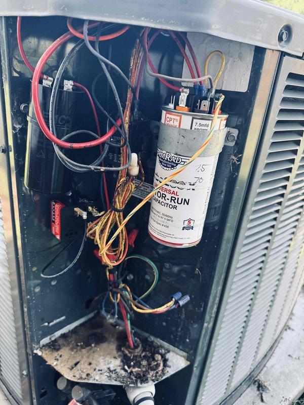 Responded to no cooling complaint on 16-year-old central air conditioning system maintaining 78-80°F instead of typical 72-73°F setpoint. Replaced air filters and fuses earlier in morning, but unit continued to fail to produce cold air. Performed diagnostic testing using digital multimeter to check electrical components and capacitor function. Removed access panel and inspected internal components including run capacitor (2.5 MFD, 370VAC), wiring connections, and control assembly. Noted accumulated debris and dirt in base of unit compartment. Verified capacitor readings and electrical continuity throughout system to identify root cause of cooling failure.