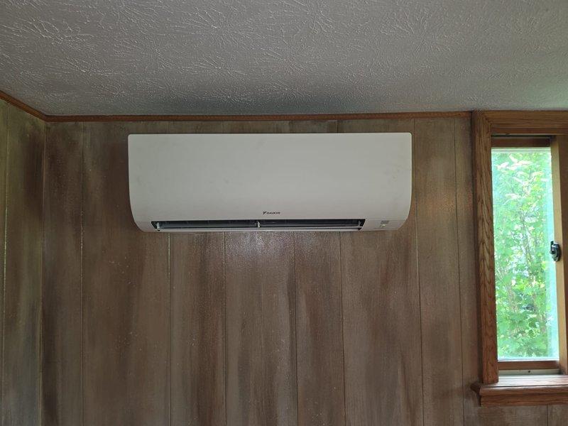 Completed installation of a two-head ductless mini-split system in a brick residence. Mounted indoor air handler units in two separate rooms with wood-paneled and standard wall finishes, ran refrigerant lines and electrical connections between outdoor condenser and indoor units, and concealed all line sets using appropriate line hide covers for a clean, professional appearance. All components tested and operational upon completion.