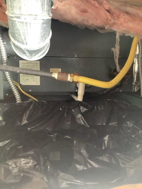Responded to service call for 19-year-old air conditioning system with clogged condensate drain line causing water accumulation in garage. Upon arrival, accessed air handler unit in attic space and inspected condensate drainage system. Located blockage in primary drain line preventing proper water discharge. Cleared obstruction from condensate line using appropriate tools and techniques to restore proper drainage flow. Verified condensate pump and trap assembly were functioning correctly. Tested system operation to confirm water was draining properly through cleared line with no further backup or overflow. System returned to normal operation with condensate draining as designed.