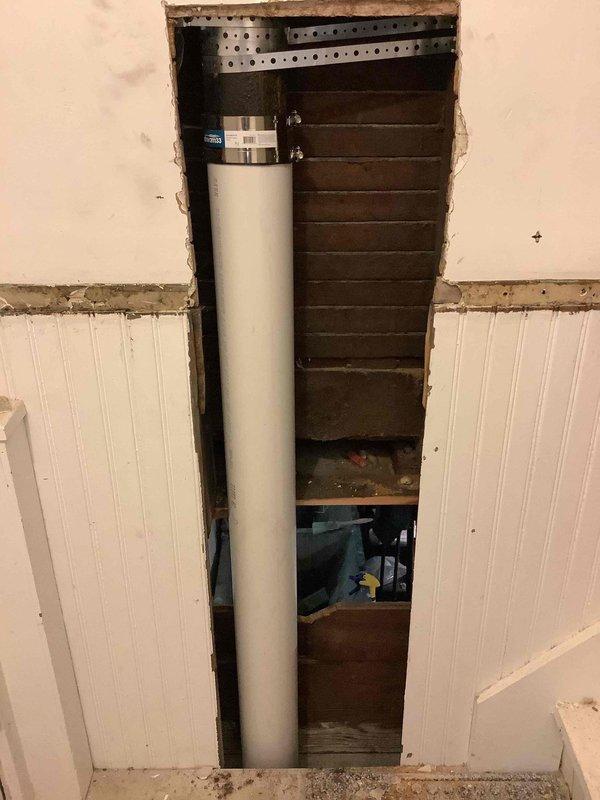 Replaced a cracked section of 4-inch cast iron drain pipe located within the wall cavity between the kitchen and basement stairwell. Cut access openings through drywall and beadboard paneling to expose the damaged cast iron pipe, removed the compromised section, and installed new PVC pipe with proper no-hub couplings and stainless steel clamps to ensure a watertight seal. Secured the new pipe assembly with metal brackets and restored structural integrity to the drainage system.