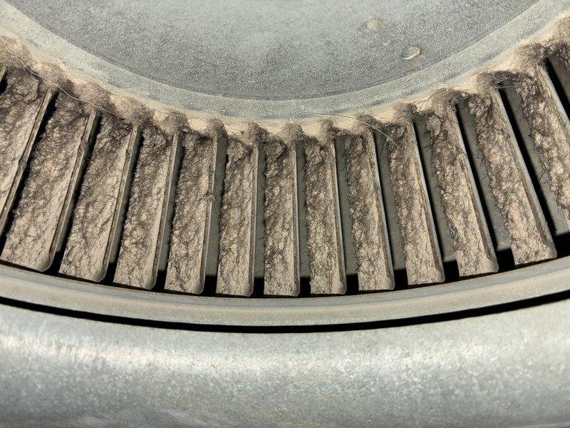 Responded to no cooling complaint on 5-year-old air conditioning system. Upon inspection, found blower wheel heavily coated with dust and debris, restricting airflow, and condenser coil significantly obstructed with dirt and grime accumulation. Cleaned blower assembly and condenser coil, restoring proper airflow and heat transfer capability. System tested and verified cooling operation restored to manufacturer specifications.