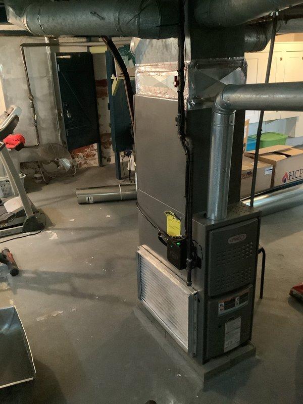 Completed return ductwork installation for add-on air conditioning system in basement mechanical room. Verified proper connection of dark green metal return ducts to existing furnace unit, ensuring adequate airflow for newly installed AC system. Collected payment from customer upon completion of work.