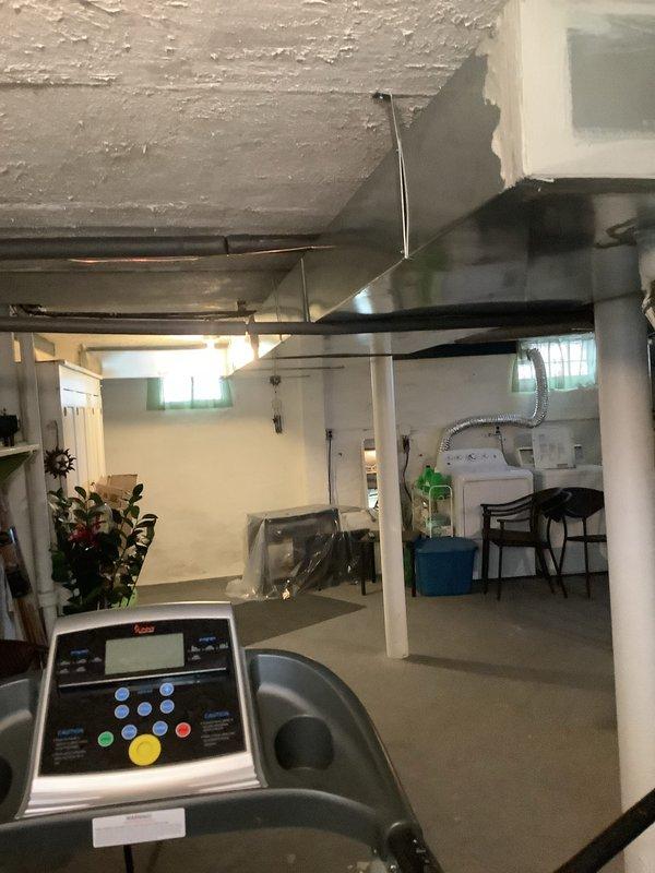 Completed return ductwork installation for add-on air conditioning system in basement mechanical room. Verified proper connection of dark green metal return ducts to existing furnace unit, ensuring adequate airflow for newly installed AC system. Collected payment from customer upon completion of work.