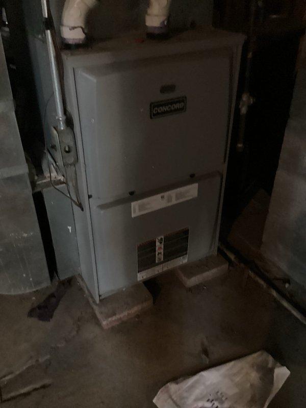 Responded to service call for 9-year-old central air conditioning system not cooling properly. Upon inspection, found outdoor condenser coil heavily clogged with dirt, dust, and debris accumulation, with coil fins barely visible beneath thick matted buildup. Debris obstruction was preventing proper airflow and heat transfer, significantly reducing system efficiency and cooling capacity. Performed thorough coil cleaning to remove all accumulated material from condenser fins. Inspected indoor Concord air handler unit and verified proper operation. System airflow restored to manufacturer specifications, allowing unit to achieve proper cooling performance.