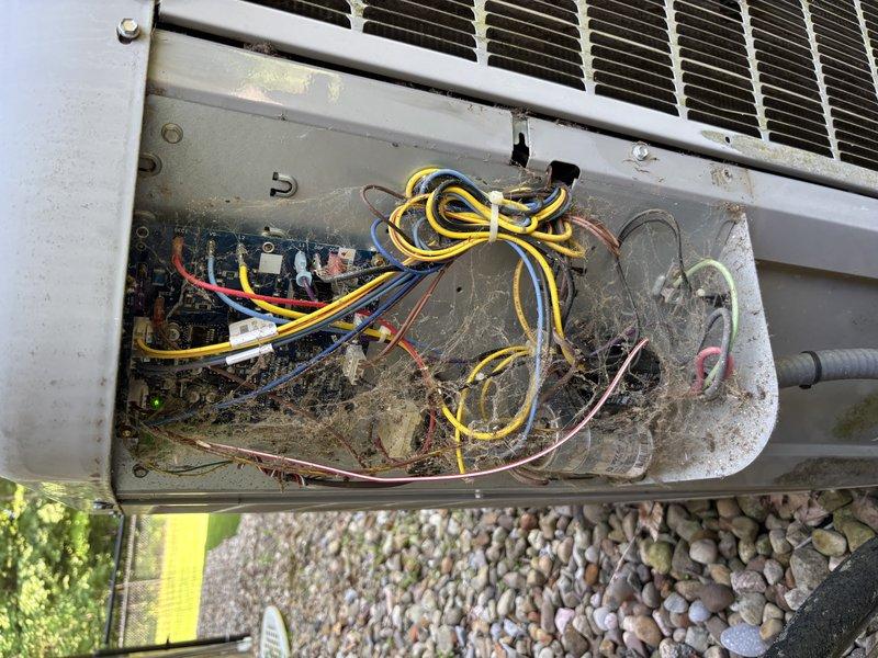 # HVAC Service Report

## Summary
Responded to service call for 12-year-old Carrier air conditioning unit displaying pressure error message and complete system failure. Performed diagnostic evaluation, accessed electrical compartment which revealed significant debris accumulation and weathering consistent with unit age, and documented outdoor condenser unit condition showing environmental exposure and maintenance needs.

## Work Performed

Arrived on-site to diagnose non-operational air conditioning system affecting entire residence. Unit presented with pressure-related error code on display. Conducted visual inspection of outdoor condenser unit positioned on composite deck platform with gravel surround.

Removed electrical compartment access panel to examine internal components and wiring. Found extensive accumulation of dirt, debris, and cobwebs throughout electrical compartment, indicating prolonged exposure to outdoor elements without routine maintenance. Inspected circuit board an