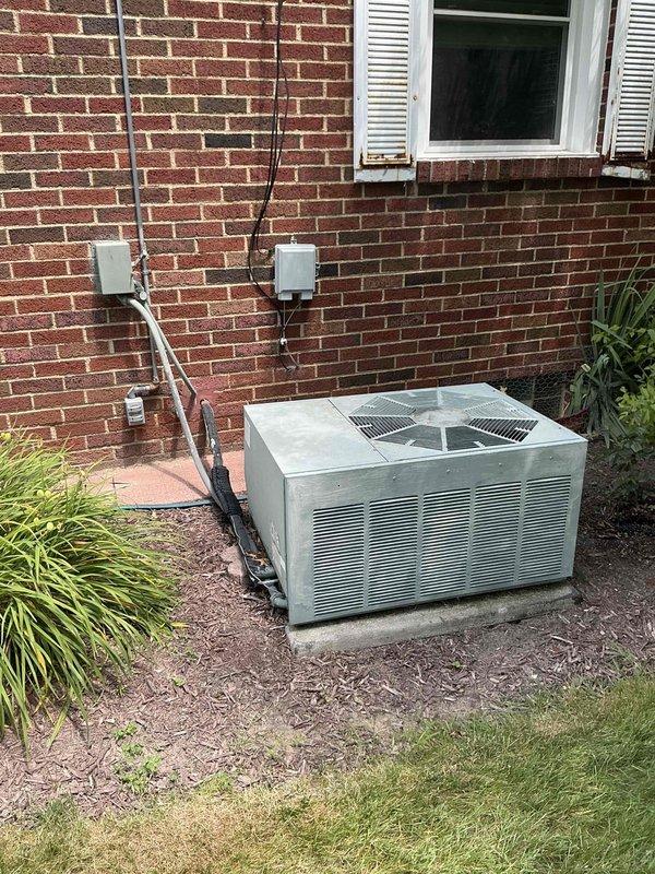 Completed comprehensive estimate for replacement of 30-year-old gas furnace and air conditioning system. Assessed existing outdoor condenser unit positioned on concrete pad against brick exterior wall and indoor furnace unit located in basement utility area with associated ductwork and venting systems. Documented current equipment condition, measured existing installation specifications, and photographed both interior and exterior components to provide accurate replacement recommendations for aging HVAC system nearing end of service life.