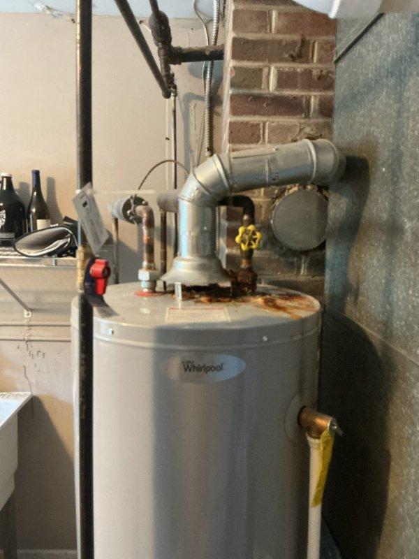 Conducted on-site assessment of 10.5-year-old 40-gallon residential water heater showing visible signs of deterioration, including significant rust staining around top pipe connections and fittings. Provided estimate for complete water heater replacement unit with professional installation recommendations.