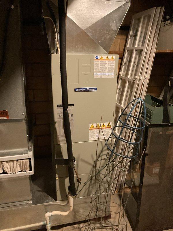 Responded to no cooling complaint on 50-year-old basement air conditioning unit. Upon arrival, inspected the basement-located air handler and associated components. Photographed equipment including the blower motor assembly with visible manufacturer labeling and electrical connections, as well as the overall installation showing the air handler unit with plenum and condensate drainage system. Per customer request, did not inspect the 25-year-old attic unit which was reported to be operating normally.
