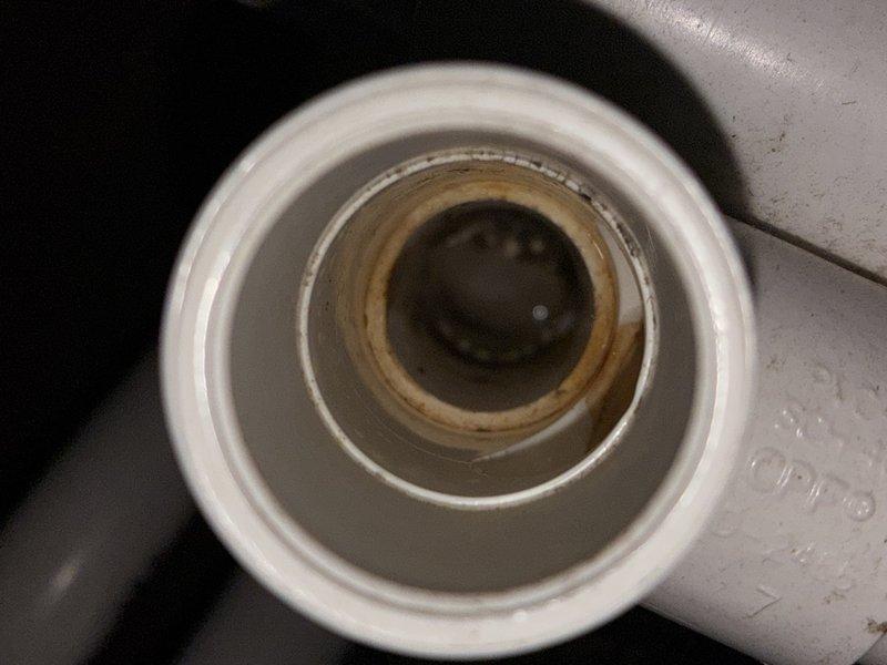 Completed scheduled HVAC maintenance visit on a 6-year-old air conditioning system located in attic space. Performed inspection of evaporator coil assembly and air filter, noting dust accumulation on mesh filter surface requiring attention. Inspected condensate drain line assembly, observing water staining and age-related discoloration on drain pipe rings. Documented system condition with photographs for maintenance records.