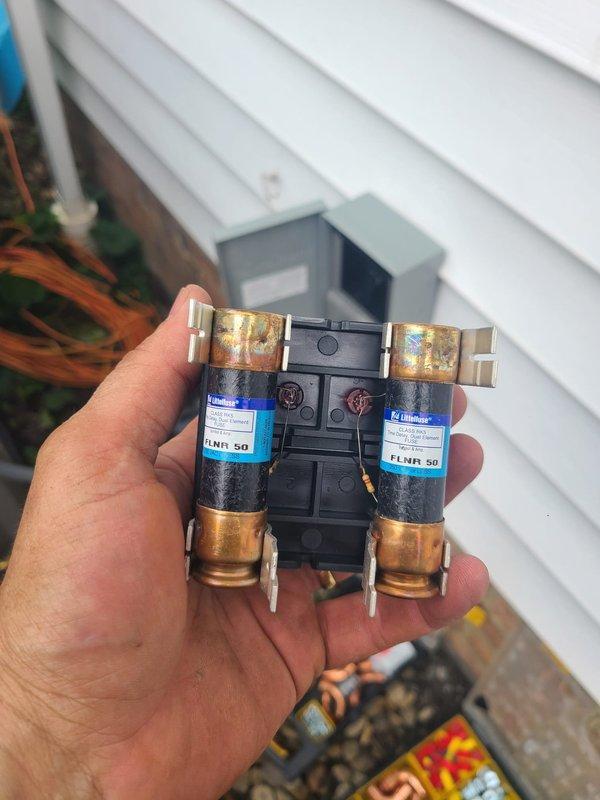 Completed installation of new air conditioning system with outdoor condenser unit and evaporator coil. Installed 50-amp Bussmann FLNR time-delay fuses in exterior disconnect box, positioned condenser unit on concrete pad with proper clearances, connected refrigerant lines through building foundation, and performed system startup with manifold gauge set to verify proper refrigerant charge and operating pressures.
