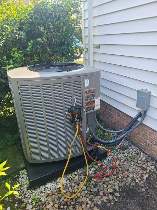 Completed installation of new air conditioning system with outdoor condenser unit and evaporator coil. Installed 50-amp Bussmann FLNR time-delay fuses in exterior disconnect box, positioned condenser unit on concrete pad with proper clearances, connected refrigerant lines through building foundation, and performed system startup with manifold gauge set to verify proper refrigerant charge and operating pressures.