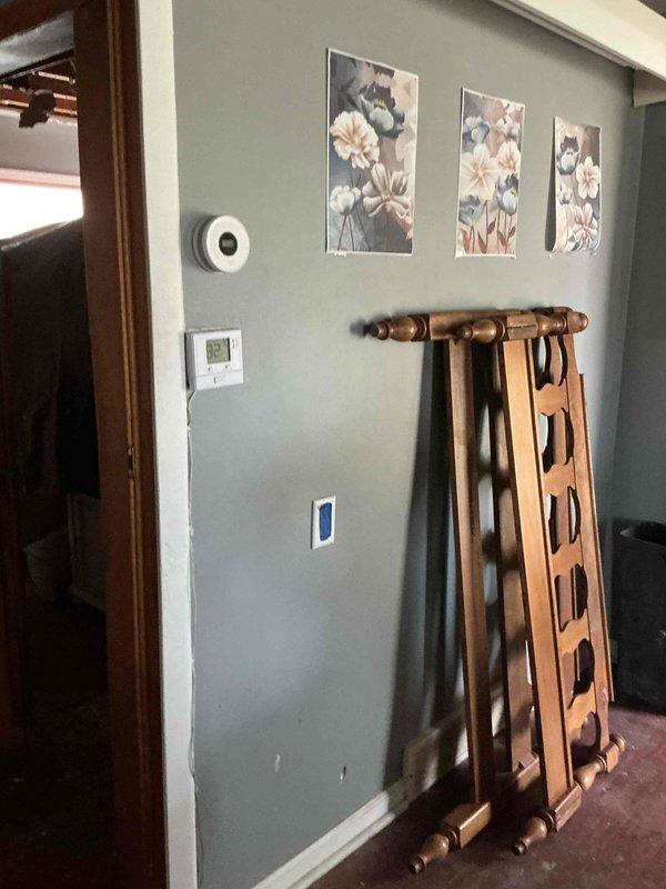 Conducted comprehensive electrical assessment of residential property following second-floor fire damage. Documented existing electrical infrastructure including exterior meter base, service entrance conductors, and interior wiring conditions. Photographed weathered exterior electrical components and interior spaces to support full house rewiring estimate for insurance and restoration purposes.