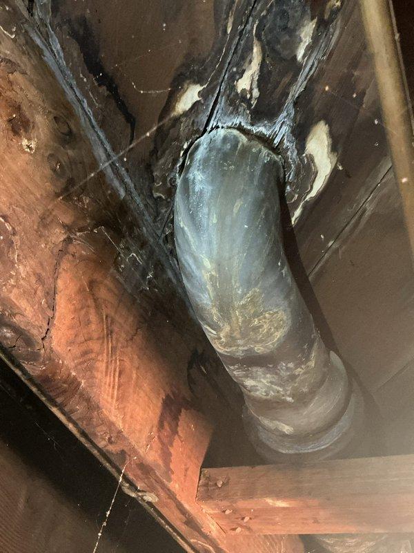 Responded to service call for toilet wax ring failure and new toilet installation request. Upon arrival, inspected existing white ceramic toilet with older-style porcelain tank showing significant interior discoloration and mineral buildup. Confirmed wax ring seal had deteriorated, causing potential leak at floor flange connection. Removed existing toilet fixture by disconnecting water supply line, unbolting from floor flange, and carefully lifting unit to prevent further water damage to dark tile flooring. Scraped old wax ring residue from floor flange and toilet base, ensuring clean mounting surface. Inspected closet flange for damage or deterioration and confirmed structural integrity for new installation. Installed new toilet fixture per customer request, positioning unit on fresh wax ring seal and securing with corrosion-resistant closet bolts. Reconnected water supply line with new flexible supply hose, verified proper alignment, and tested flush mechanism for proper operation. C