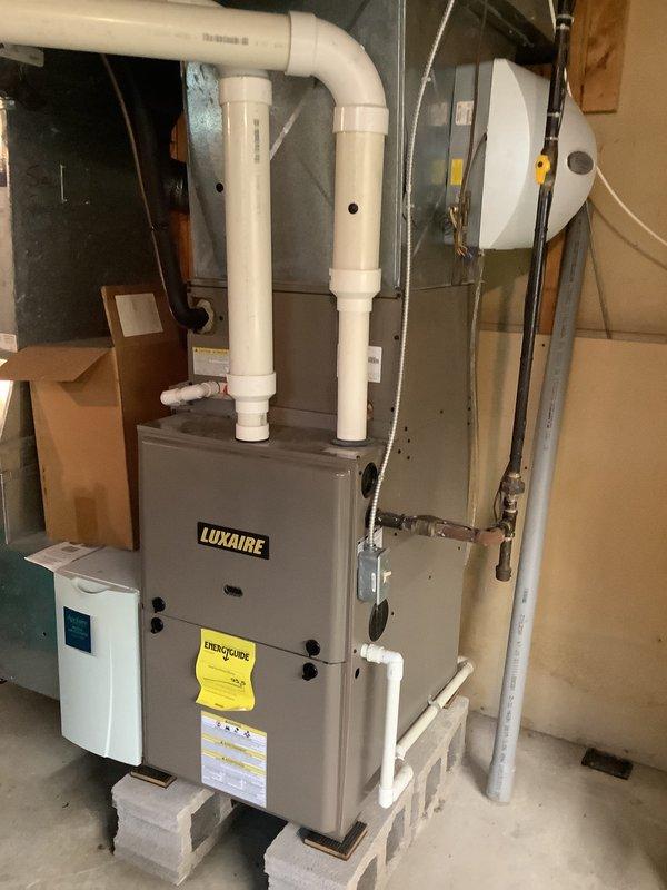 Completed estimate for furnace and air conditioning system replacement. Existing installation includes Luxaire furnace with proper PVC venting, Aprilaire humidifier mounted to main supply ductwork, and associated mechanical components in basement utility area. All equipment evaluated for replacement sizing and configuration requirements.