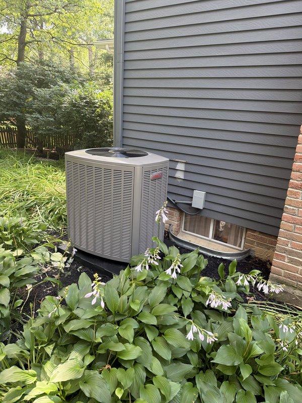 Completed installation of 80% AFUE gas furnace and air conditioning system at residential property. Installed new outdoor condensing unit on concrete pad with proper clearances from structure and landscaping. Unit positioned against gray vinyl siding exterior with adequate airflow access on all sides. Mounted dual-pole electrical contactor with FLNR fuses rated for system amperage requirements, ensuring proper electrical connections at copper terminals. Verified all electrical components functioning correctly with appropriate voltage supply. System tested and confirmed operational upon completion of installation.