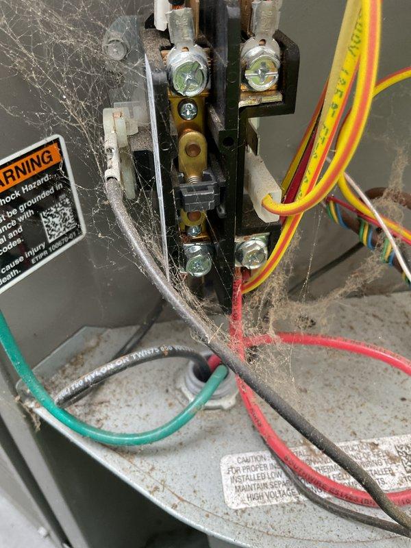 Completed scheduled air conditioning maintenance service with 8am arrival as confirmed. Performed comprehensive system inspection including electrical connections and outdoor disconnect components. Noted significant cobweb accumulation and dust buildup within electrical junction box indicating extended service interval. All terminal connections, wiring, and safety labels verified to be in functional condition despite cosmetic debris. Exterior meter disconnect box and associated conduit connections inspected and found operational.