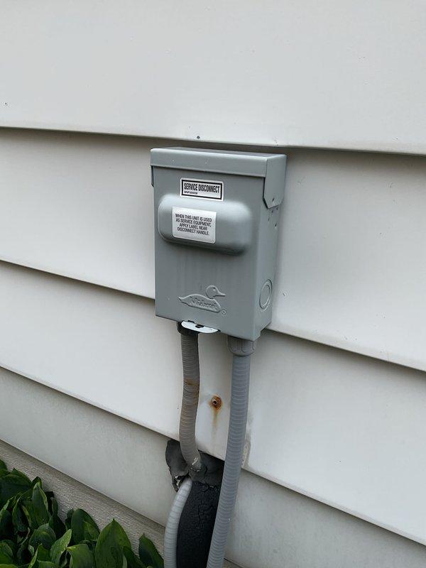 Completed scheduled air conditioning maintenance service with 8am arrival as confirmed. Performed comprehensive system inspection including electrical connections and outdoor disconnect components. Noted significant cobweb accumulation and dust buildup within electrical junction box indicating extended service interval. All terminal connections, wiring, and safety labels verified to be in functional condition despite cosmetic debris. Exterior meter disconnect box and associated conduit connections inspected and found operational.