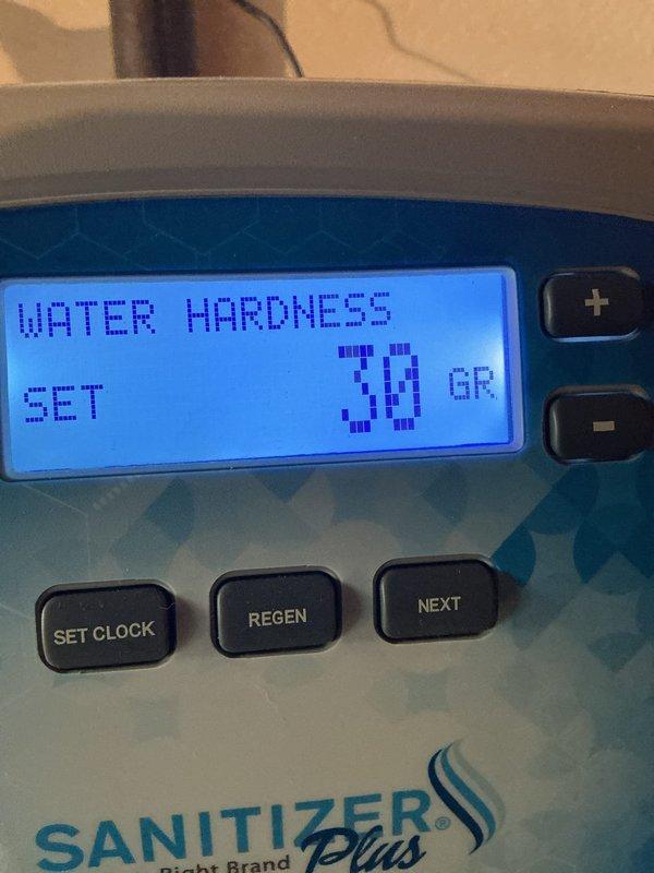 Delivered eight bags of solar salt for water softener system as part of recurring maintenance service. Restocked salt supply in utility room adjacent to water treatment equipment, which included a water softener unit with digital control panel displaying hardness setting of 30 grains. Verified proper placement of salt bags near treatment system for customer accessibility.