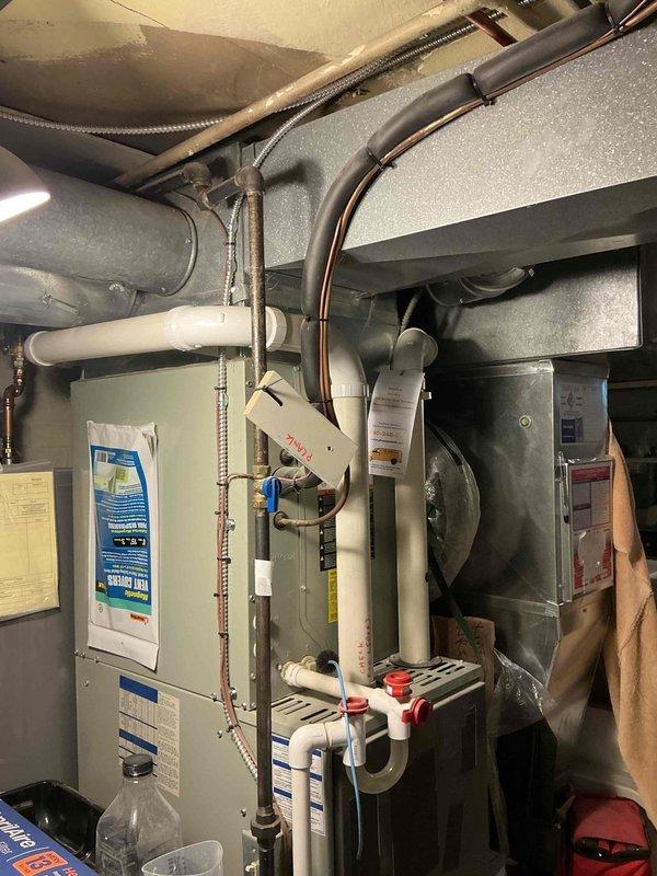 Conducted comprehensive assessment of existing 16-year-old HVAC system including Carrier XR13 condensing unit and gas furnace with blower assembly for replacement estimate. Both units showing signs of age-related wear and weathering, with outdoor condenser exhibiting surface discoloration and indoor equipment displaying typical operational wear patterns. Documented existing system configuration including refrigerant line routing, PVC condensate drainage, electrical connections, and ductwork integration to provide accurate replacement specifications and ensure proper sizing for new equipment installation.