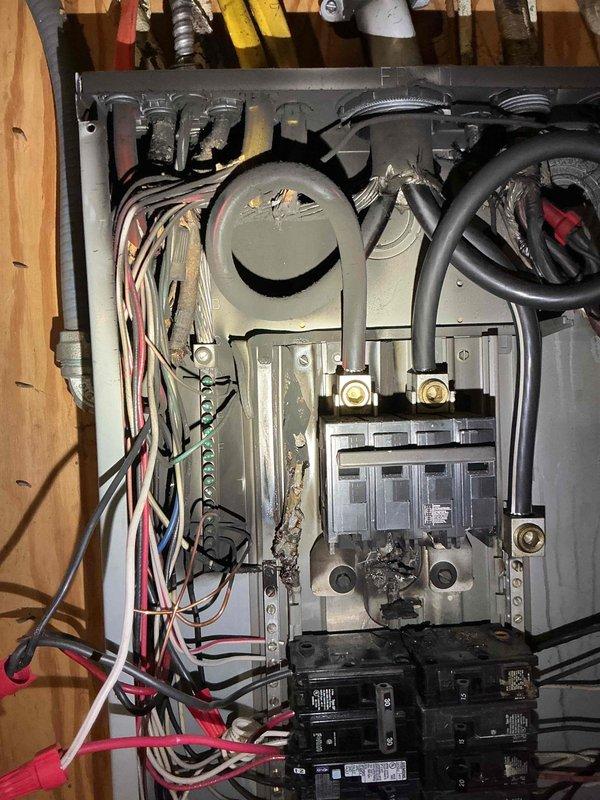 Responded to emergency service call for overheated and damaged electrical panel in 1957-built residence. Upon inspection, found obsolete main breaker assembly with significant heat damage, discoloration, and deteriorated internal components. Removed failed main breaker mechanism and assessed overall panel condition, which showed signs of age-related wear, dust accumulation, and outdated wiring configuration. Documented existing electrical service entrance cables and circuit distribution system. Recommended complete panel replacement due to safety concerns with vintage equipment and heat-compromised components in the 69-year-old installation.