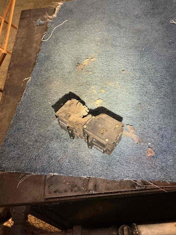 Responded to emergency service call for overheated and damaged electrical panel in 1957-built residence. Upon inspection, found obsolete main breaker assembly with significant heat damage, discoloration, and deteriorated internal components. Removed failed main breaker mechanism and assessed overall panel condition, which showed signs of age-related wear, dust accumulation, and outdated wiring configuration. Documented existing electrical service entrance cables and circuit distribution system. Recommended complete panel replacement due to safety concerns with vintage equipment and heat-compromised components in the 69-year-old installation.