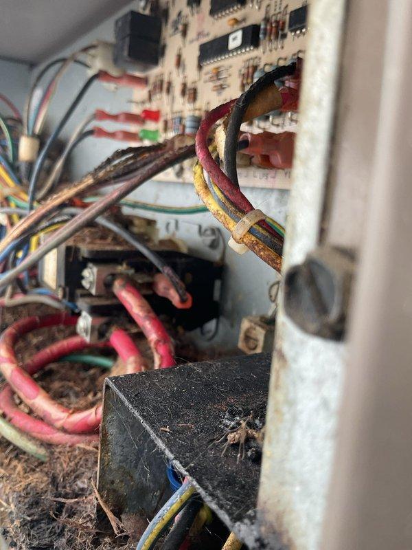 Responded to no cooling call on 13-year-old air conditioning system with four-zone thermostat configuration. Upon inspection, discovered severe electrical component deterioration in control panel due to extensive moisture exposure and environmental contamination. Found critical corrosion throughout wire bundles, compromised wire insulation integrity, oxidized circuit board components, and corroded relay/transformer assemblies. Documented heavy accumulation of debris, dust, and organic material on electrical connections and terminal blocks. Advised customer of unsafe operating conditions and recommended immediate system evaluation for potential control board replacement and complete rewiring of affected circuits to restore safe operation.