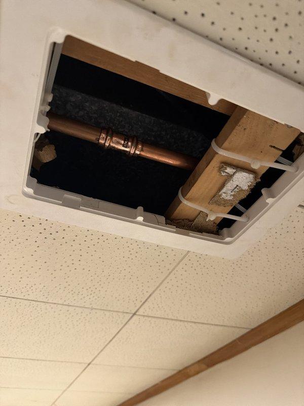 Replaced rear exterior hose bib (faucet) on brick structure. Accessed copper supply line through interior ceiling plenum, cut and soldered new copper piping connections to install frost-free sillcock. Verified proper drainage slope and sealed exterior wall penetration to prevent water intrusion.