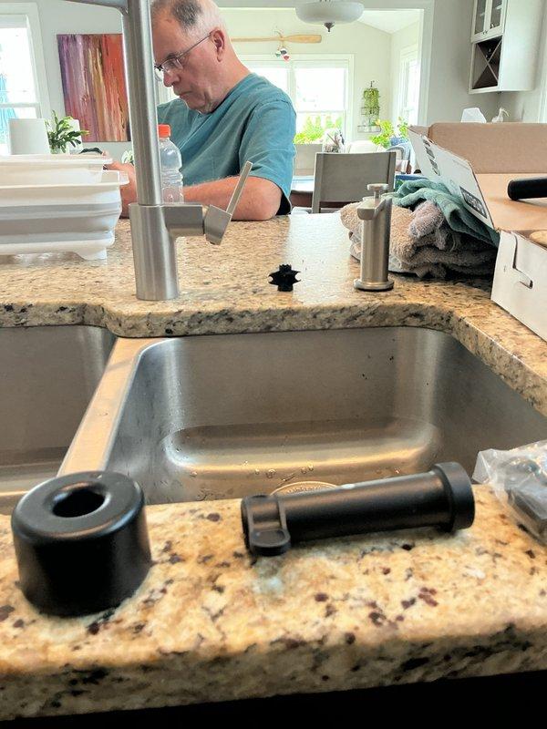 Completed kitchen faucet replacement, removing existing fixture and installing new Delta model matte black pull-down faucet with spring-style design and flexible spray head. Disconnected water supply lines, removed old faucet assembly and mounting hardware from granite countertop with double-basin undermount sink. Installed new faucet deck plate, secured mounting hardware, connected hot and cold water supply lines, and attached flexible hose assembly. Tested water flow and spray functions, checked all connections for leaks, and verified proper operation of pull-down mechanism and spray head settings.