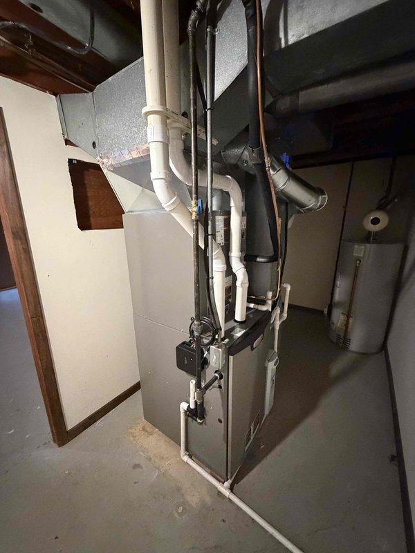 Completed first-stage air conditioning installation including outdoor condensing unit and indoor evaporator coil. Installed new disconnect box with Littelfuse fuses at outdoor unit location, established proper electrical connections, and integrated new evaporator coil with existing furnace system in basement. All components tested and operational upon completion.