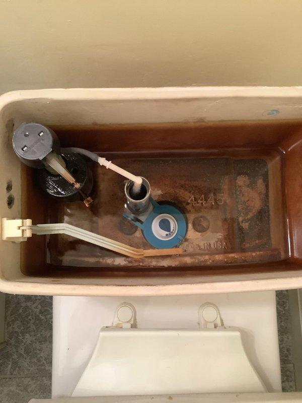 Responded to service call for toilet continuously running. Upon inspection, found deteriorated flush valve flapper and significant mineral buildup and corrosion within tank components. Diagnosed faulty seal allowing constant water flow from tank to bowl. Performed maintenance visit assessment and documented existing conditions including rusted hardware and sediment accumulation affecting proper valve operation.