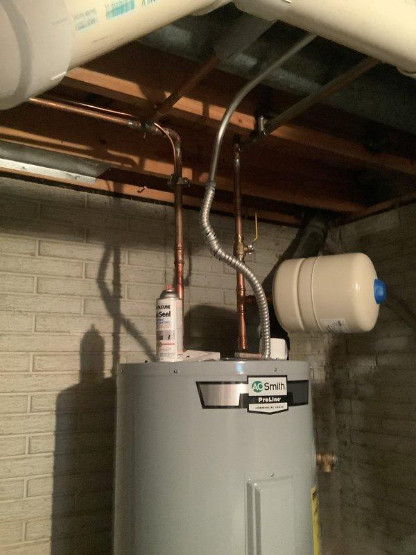 Conducted on-site evaluation for tankless water heater replacement of existing conventional A.O. Smith Proline tank-style water heater. Assessed current installation including water supply lines, gas connections, venting requirements, and electrical specifications. Documented existing setup with traditional storage tank water heater, expansion tank, copper piping configuration, and flexible gas line connections. Provided comprehensive estimate for conversion to tankless system, including necessary modifications to gas line sizing, electrical requirements, venting upgrades, and plumbing reconfiguration required for tankless unit installation.