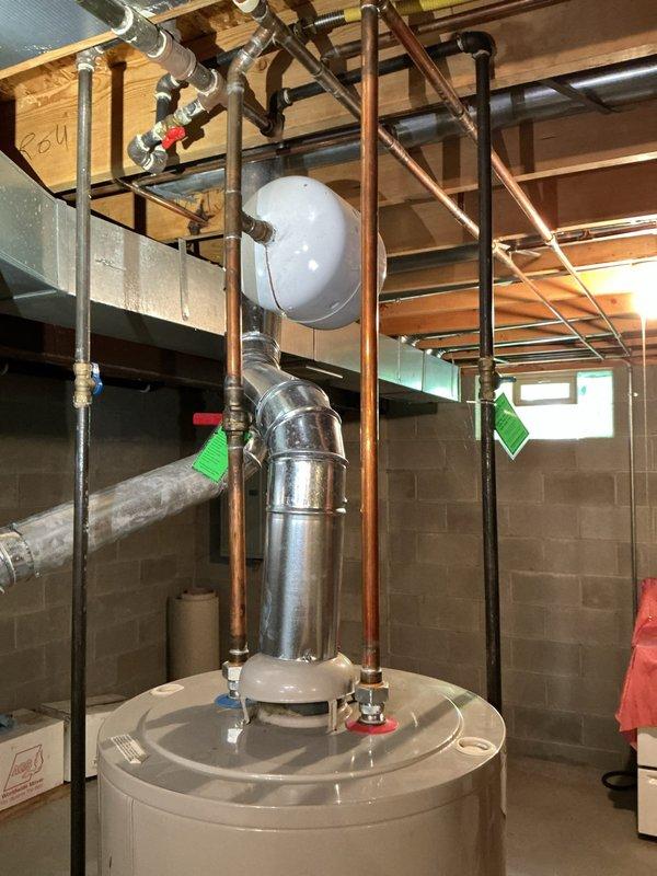 Responded to emergency call for water heater failure with active leak in basement. Upon arrival, found existing A.O. Smith tanked water heater experiencing catastrophic failure with water damage to surrounding area. Completed full water heater replacement, installing new unit with proper copper piping connections, expansion tank, and code-compliant plumbing infrastructure. System tested and verified operational with no leaks detected.