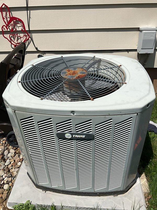 Completed MVP cooling maintenance visit on 20-year-old Trane air conditioning system. Performed comprehensive inspection of outdoor condenser unit, noting rust formation on fan hub assembly and significant cobweb accumulation within electrical panel compartment. Cleaned electrical connections, removed debris from terminal blocks, and verified proper wire terminations on all colored conductors. Inspected unit operation, confirmed proper function of all components, and ensured system safety protocols were maintained throughout service visit.