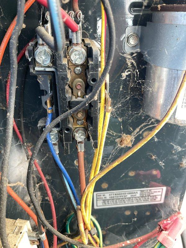 Completed MVP cooling maintenance visit on 20-year-old Trane air conditioning system. Performed comprehensive inspection of outdoor condenser unit, noting rust formation on fan hub assembly and significant cobweb accumulation within electrical panel compartment. Cleaned electrical connections, removed debris from terminal blocks, and verified proper wire terminations on all colored conductors. Inspected unit operation, confirmed proper function of all components, and ensured system safety protocols were maintained throughout service visit.
