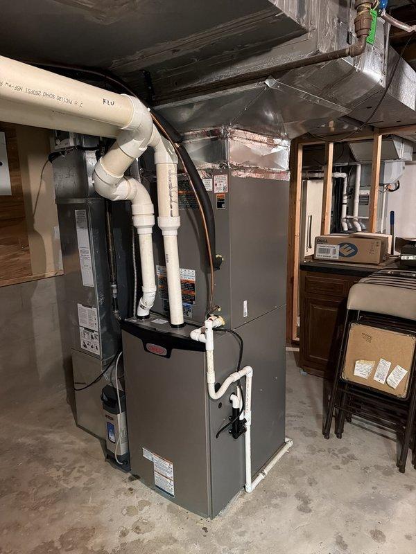 Completed second phase of split system air conditioning installation including outdoor condensing unit mounted on exterior brick wall with proper electrical disconnect and indoor evaporator coil integrated with existing furnace system. All refrigerant lines, condensate drainage, and electrical connections installed per manufacturer specifications with system tested and operational.