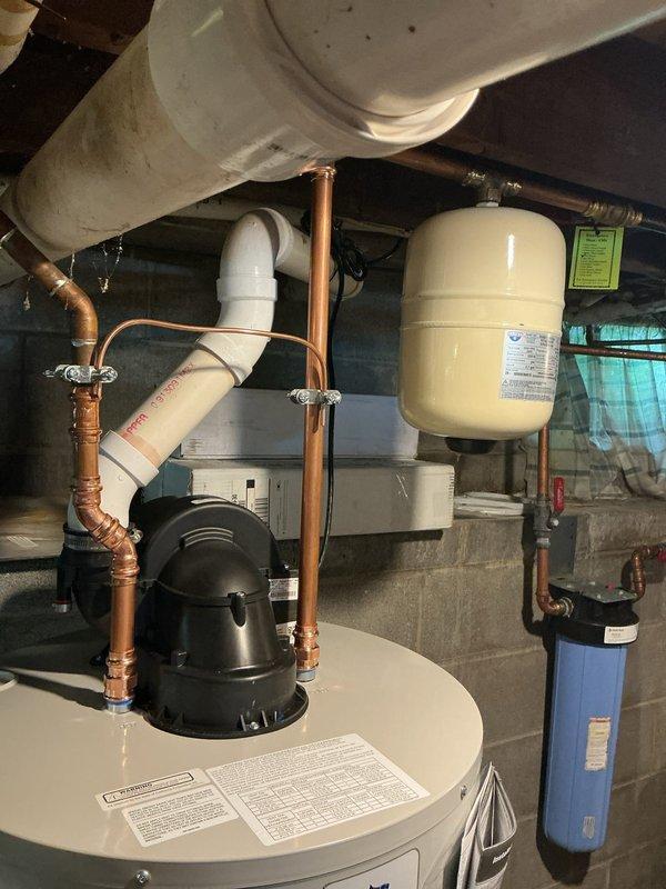 Replaced existing 59-gallon Bradford White power vent water heater with new 50-gallon Bradford White power vent unit (Model RG1PV50S6N1) featuring 6-year manufacturer warranty. Installation included replacement of expansion tank, upgrade from aluminum drain pan to lifted plastic pan with connection to existing PVC drain line, and integration with existing copper supply lines and PVC venting system. All components staged and installed per manufacturer specifications with proper clearances and code compliance.