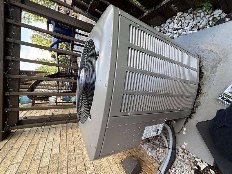Completed scheduled maintenance visit for MVP customer's outdoor air conditioning condenser unit. Performed visual inspection of split-system condenser positioned on elevated deck, confirmed unit operational status, and documented equipment condition through photographic records. Top-mounted air filter showed dirt accumulation and discoloration, indicating normal usage patterns since last service interval.