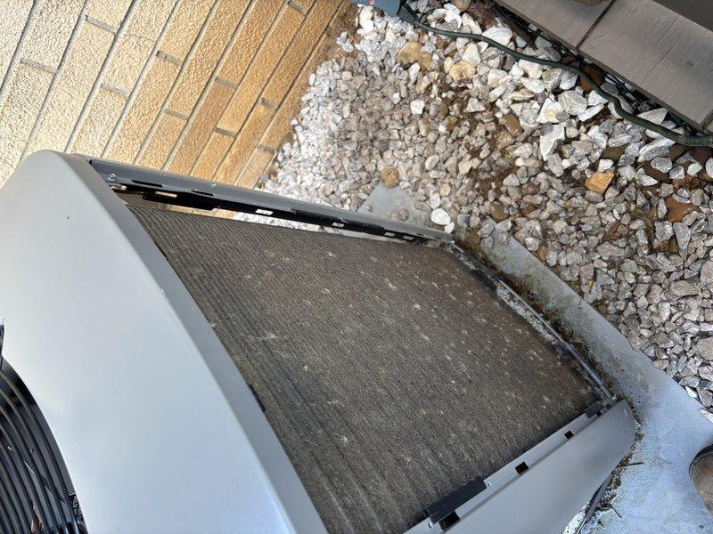 Completed scheduled maintenance visit for MVP customer's outdoor air conditioning condenser unit. Performed visual inspection of split-system condenser positioned on elevated deck, confirmed unit operational status, and documented equipment condition through photographic records. Top-mounted air filter showed dirt accumulation and discoloration, indicating normal usage patterns since last service interval.