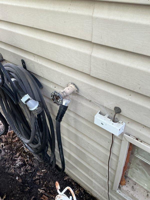 Installed new outdoor hose spigot on exterior wall of residence. Ran water supply line through foundation, mounted frost-free sillcock to vinyl siding with appropriate backing and weatherproof seal, and tested for proper operation and leak-free connections.