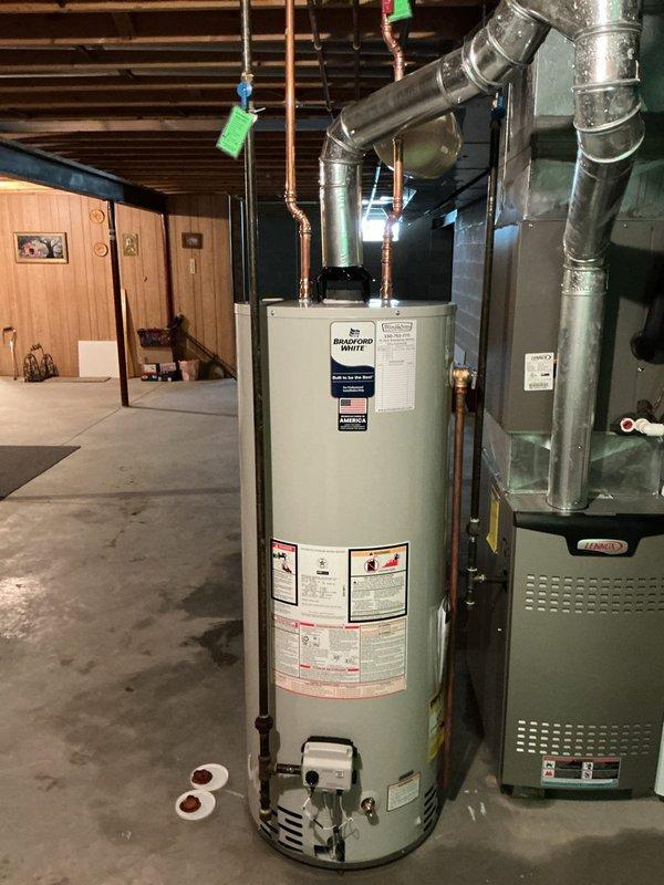 Installed a new 50-gallon Bradford White water heater with 6-year manufacturer warranty in basement utility area. Installation included new ball valve, thermal expansion tank with repositioned orientation from previous configuration, and complete copper piping connections. All components properly secured and tested for proper operation, with pressure relief valve and shutoff valves installed to code specifications.