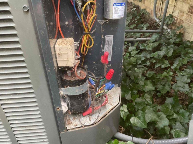 Completed preventive maintenance tune-up on 15-year-old outdoor air conditioning unit. Inspected electrical connections in control panel, noting visible corrosion on capacitor terminals and wire connections that were cleaned and tightened. Removed accumulated debris from electrical compartment, checked all wire terminations for secure connections, and verified proper operation of all system components despite age-related wear and environmental exposure.