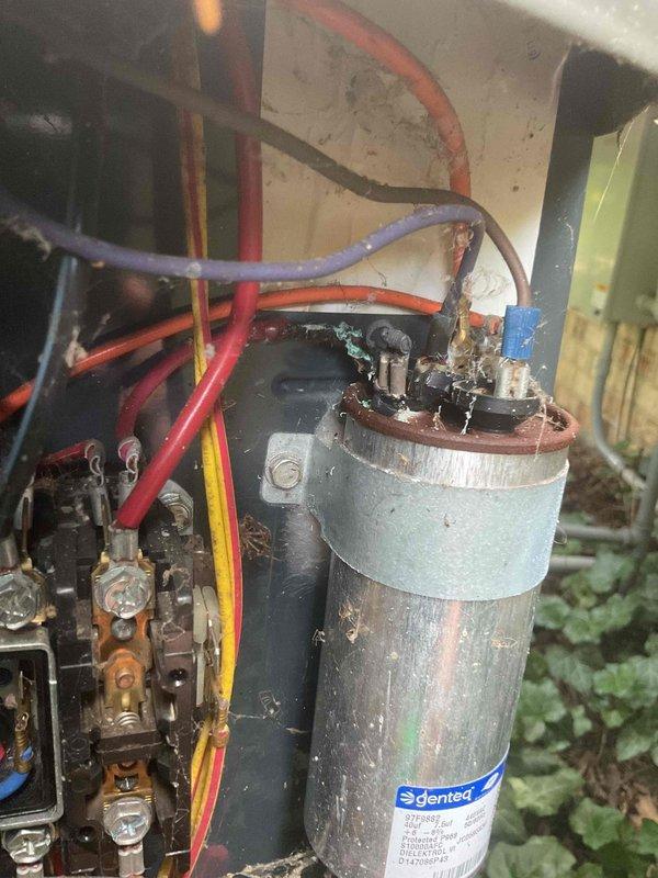 Completed preventive maintenance tune-up on 15-year-old outdoor air conditioning unit. Inspected electrical connections in control panel, noting visible corrosion on capacitor terminals and wire connections that were cleaned and tightened. Removed accumulated debris from electrical compartment, checked all wire terminations for secure connections, and verified proper operation of all system components despite age-related wear and environmental exposure.
