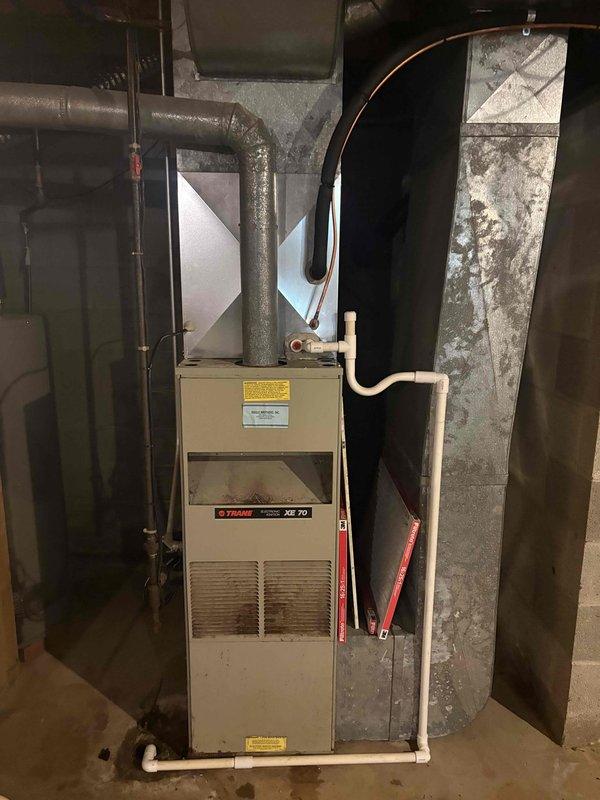 Completed A/C and coil installation as secondary job component. Replaced failed 20A Littelfuse fuses at outdoor condensing unit, which had shown signs of electrical wear and discoloration. New A/C system installed and connected to existing Trane XE 70 furnace with proper refrigerant lines, electrical connections, and condensate drainage. All ductwork connections secured, system tested for proper operation, and unit left running efficiently.