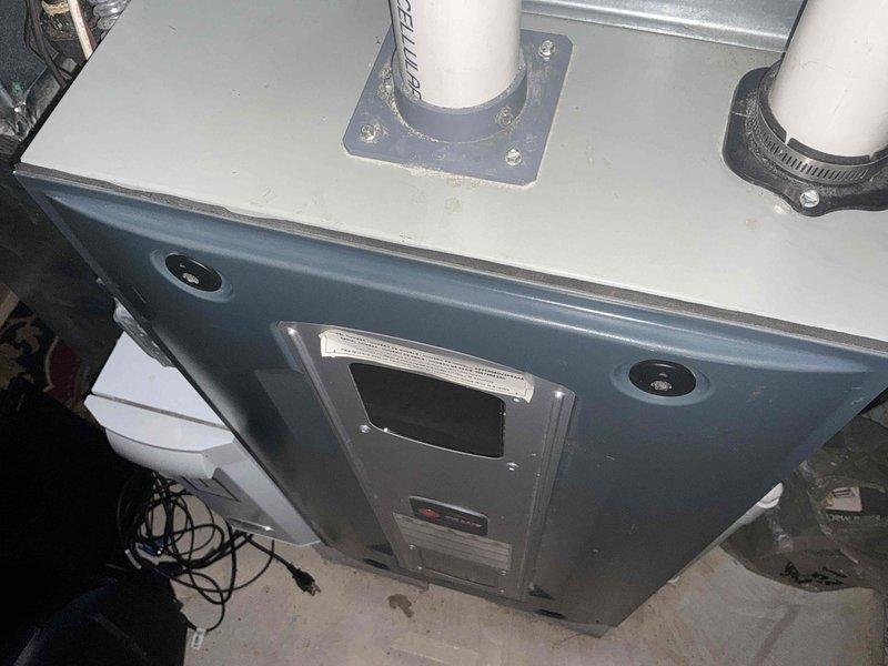 Provided comprehensive estimate for high-efficiency furnace replacement system with promotional air conditioning upgrade package. Documented existing HVAC equipment installation including current furnace unit with standard PVC venting configuration, digital control interface, and proper drainage components in basement mechanical room setting.