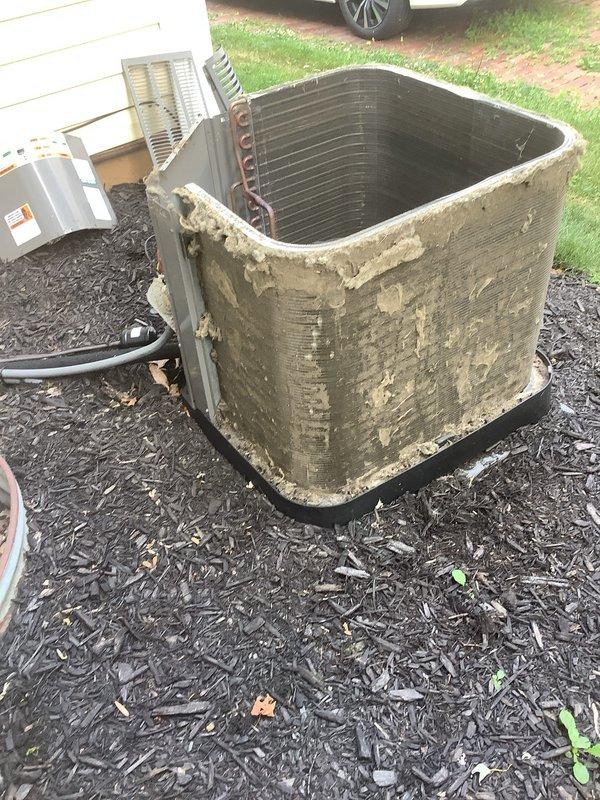 # HVAC Service Report

Responded to service call for 6-year-old air conditioning system not maintaining adequate cooling throughout residence. Upon arrival, performed visual inspection of outdoor condensing unit, which revealed significant deterioration of exterior paint and coating, heavy accumulation of dirt and organic debris on cabinet surfaces, and substantial contamination of condenser coil fins. Unit showed signs of extended environmental exposure with minimal recent maintenance. Documented equipment condition through photographs showing weathered casing, degraded foam insulation at top panel, and greenish-brown patina indicating biological growth. Condenser coil exhibited restricted airflow due to debris buildup between fins. Unit positioned on proper pad with appropriate clearances maintained. Assessed overall system performance and identified maintenance deficiencies contributing to reduced cooling capacity. Provided recommendations for thorough coil cleaning, cabinet restora
