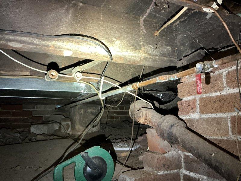 Responded to service call for outdoor spigot replacement and extension work. Accessed crawl space to assess existing plumbing infrastructure and locate water supply lines serving two outdoor spigots. Navigated through confined area with exposed copper piping, vapor barriers, and brick foundation to evaluate current spigot installations and determine optimal routing for extensions. One outdoor spigot identified as requiring complete replacement with frost-free unit to prevent freeze damage. Documented existing conditions including pipe locations, accessibility constraints, and connection points for planned extensions. Additionally provided on-site evaluation of two existing fireplaces for potential conversion to gas operation, examining firebox construction, existing ventilation, and structural considerations for future gas line installation and burner system integration.