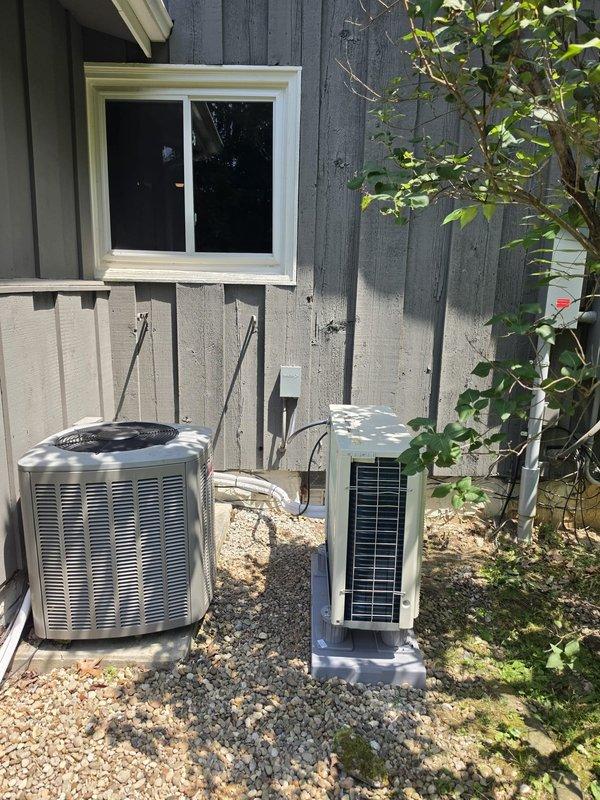 Completed installation of single-head mini-split system at residential property. Mounted outdoor condenser unit on concrete pad with proper clearances, installed indoor air handler below window, and ran refrigerant lines with insulation along exterior wall. Connected electrical service with appropriate disconnect, tested system operation, and verified proper cooling performance upon startup.