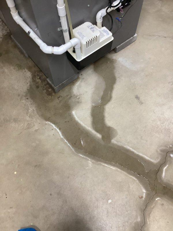 Responded to service call for 10-year-old Lennox air conditioning system running continuously without maintaining setpoint temperature and water leakage at equipment seam. Upon arrival, found significant water pooling on concrete floor surrounding HVAC unit, with moisture extending several feet from equipment base. Inspected condensate drainage system and identified clogged condensate line causing backup and overflow at drain pan seam. Cleared blockage from PVC condensate piping using appropriate tools and verified proper drainage flow. Tested condensate pump operation and confirmed pumping functionality restored. Cleaned drain pan and surrounding areas, checked refrigerant levels and airflow parameters. System now cycling properly, maintaining temperature setpoint, and draining condensate without leakage.